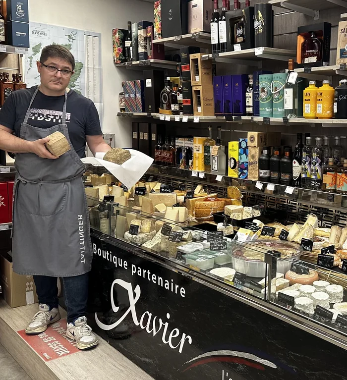 Christophe au comptoir de la boutique partenaire Fromagerie Xavier