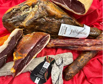 Assortiment de jambons secs et saucisses artisanales de terroir.
