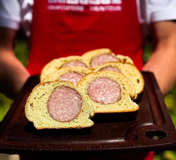 Sandwichs au saucisson grillé sur pain rustique, servis sur un plateau en bois.