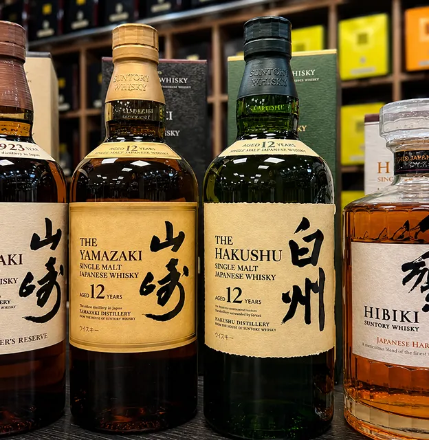 Quatre bouteilles de whisky japonais d'exception en vitrine.